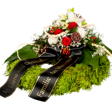 Trauerkranz mit roten Rosen und weißen Lilien